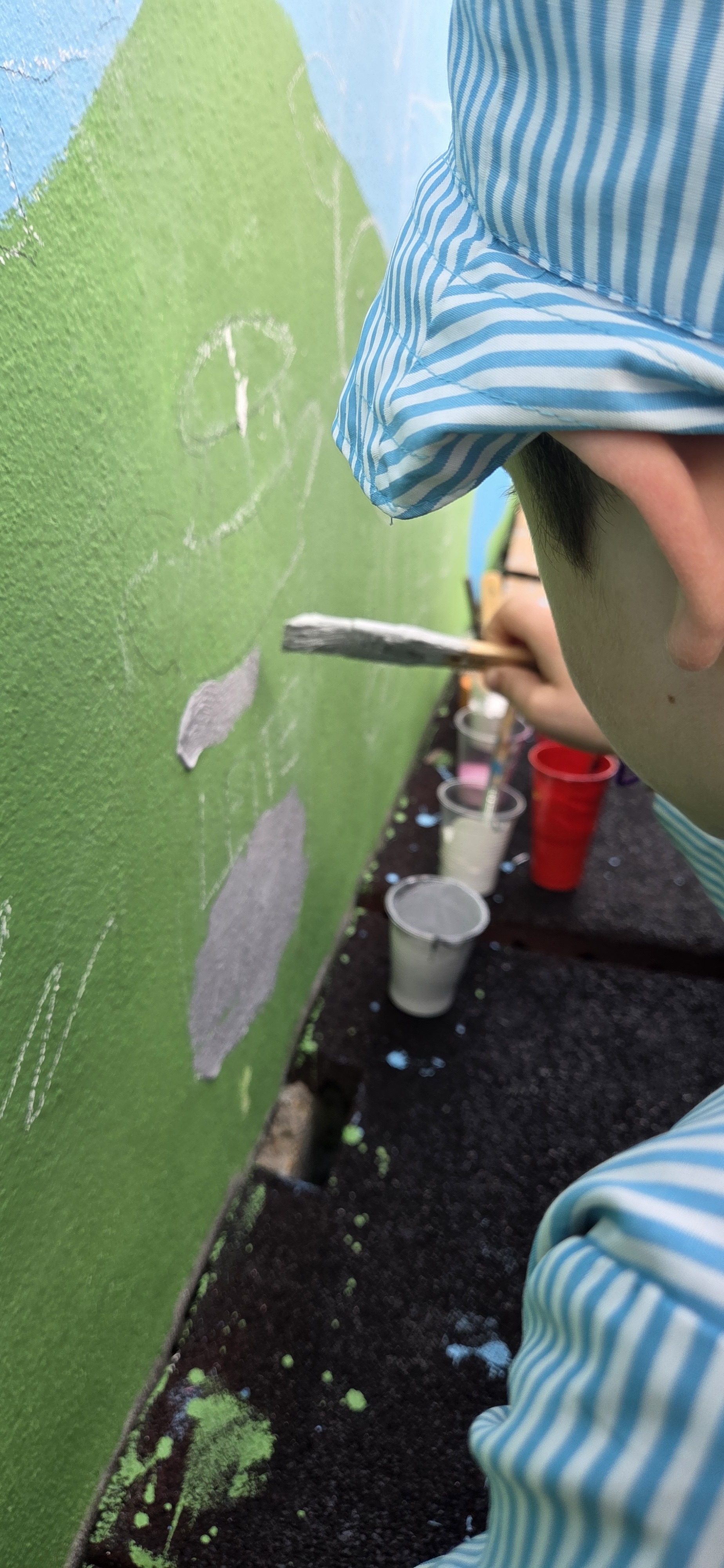 Criança a pintar a leiteira. Peça típica da região da Sanguinheira