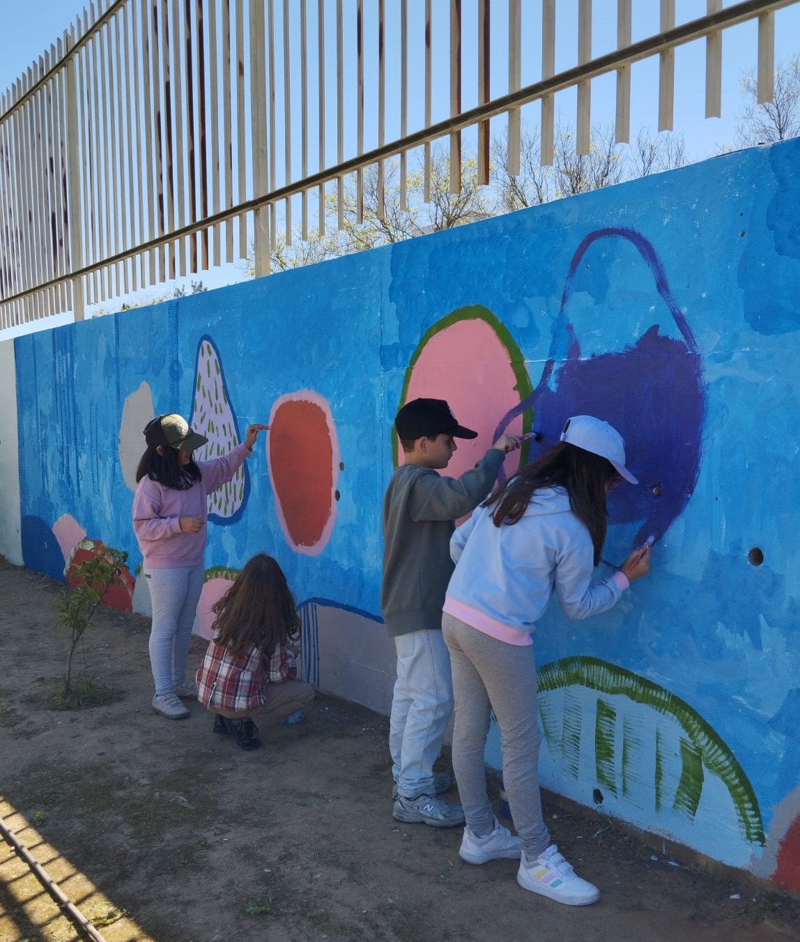 Alunos a pintarem, utilizando várias cores.